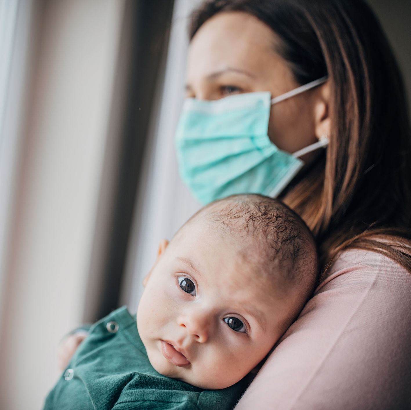Mother with protective mask holding his baby son at home do to pandemic outbreak mother with protective mask holding his baby son at home do to pandemic outbreak