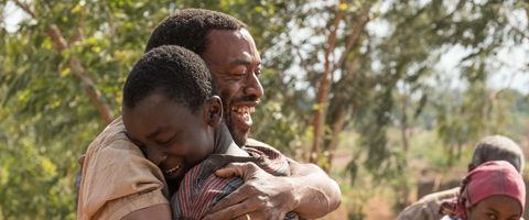 A father and son embrace happily in a scene from Boy Who Harnessed the Wind. The movie is a Good Housekeeping pick for best kids movies on Netflix a father and son embrace happily in a scene from boy who harnessed the wind the movie is a good housekeeping pick for best kids movies on netflix