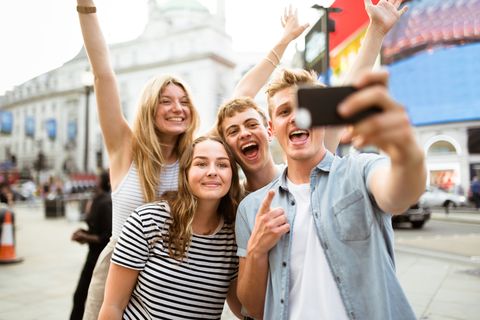friends take a selfie in piccadilly circus friends take a selfie in piccadilly circus