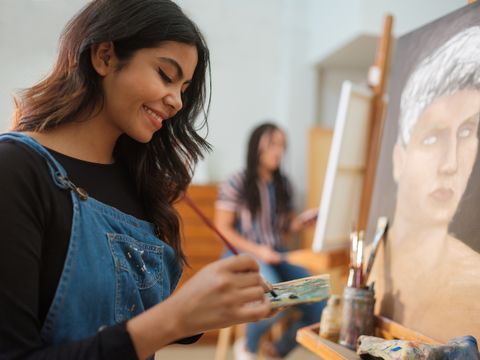 happy latin female working on a painting