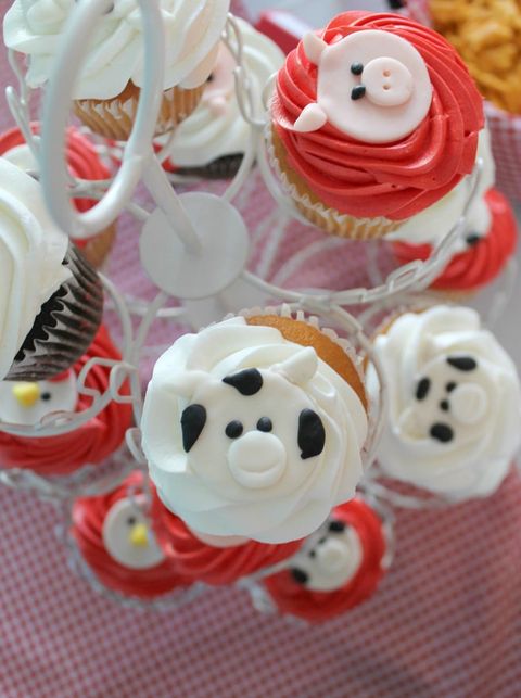 A first birthday party with a farm theme has cupcakes topped with frosting farm animals a first birthday party with a farm theme has cupcakes topped with frosting farm animals
