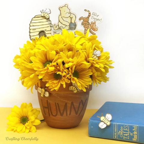 A winnie-the-pooh inspired first birthday party theme with flower-pot centerpieces made up to look like a honey pot a winnie the pooh inspired first birthday party theme with flower pot centerpieces made up to look like a honey pot