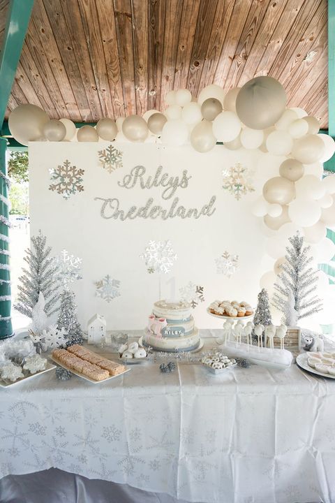 A winter wonderland first birthday party feaures wintry and silvery details including tinsel trees and snowflake cookies a winter wonderland first birthday party feaures wintry and silvery details including tinsel trees and snowflake cookies
