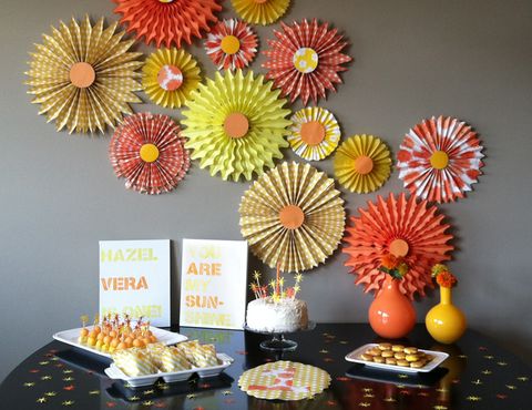 a first birthday party with a sunshine theme including paper sun decorations and yellow foods a first birthday party with a sunshine theme including paper sun decorations and yellow foods