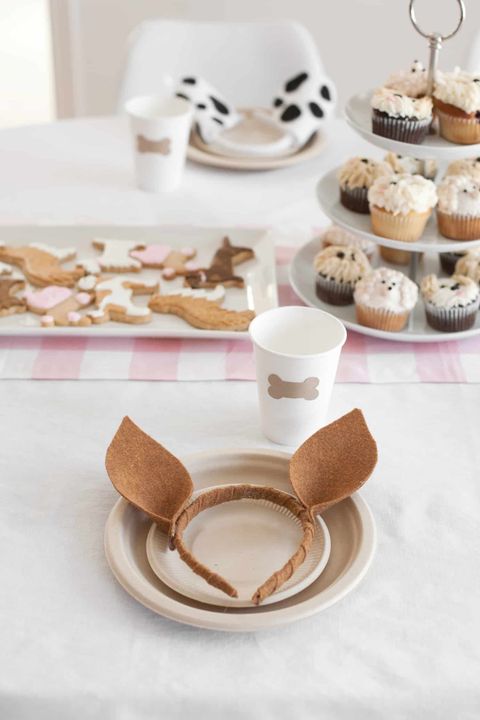 A puppy themed first birthday party includes dog ears and cookies shaped like dog biscuits a puppy themed first birthday party includes dog ears and cookies shaped like dog biscuits