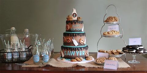 A milk and cookies themed first birthday party includes a cake, milk bottles with striped straws and chocolate chip cookies a milk and cookies themed first birthday party includes a cake, milk bottles with striped straws and chocolate chip cookies