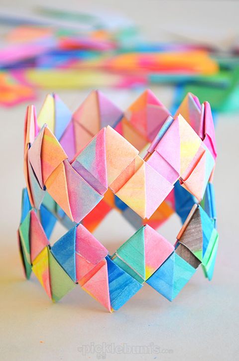 a colorful diy folded paper bracelet sits on a table the project is a good housekeeping pick for best activities for kids