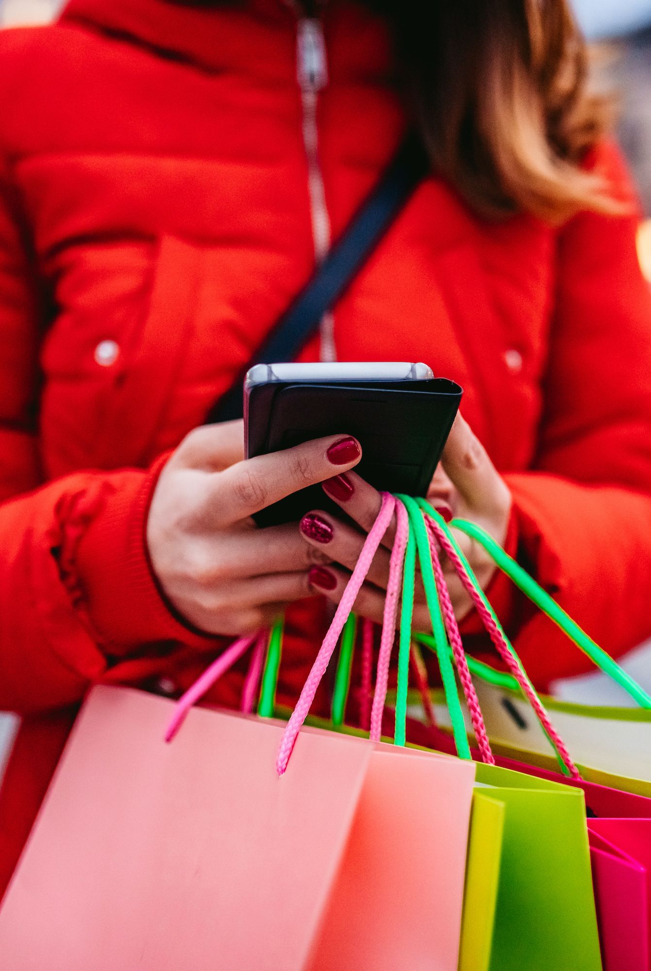 Fall Activities - early holiday shopping woman with shopping bags using phone