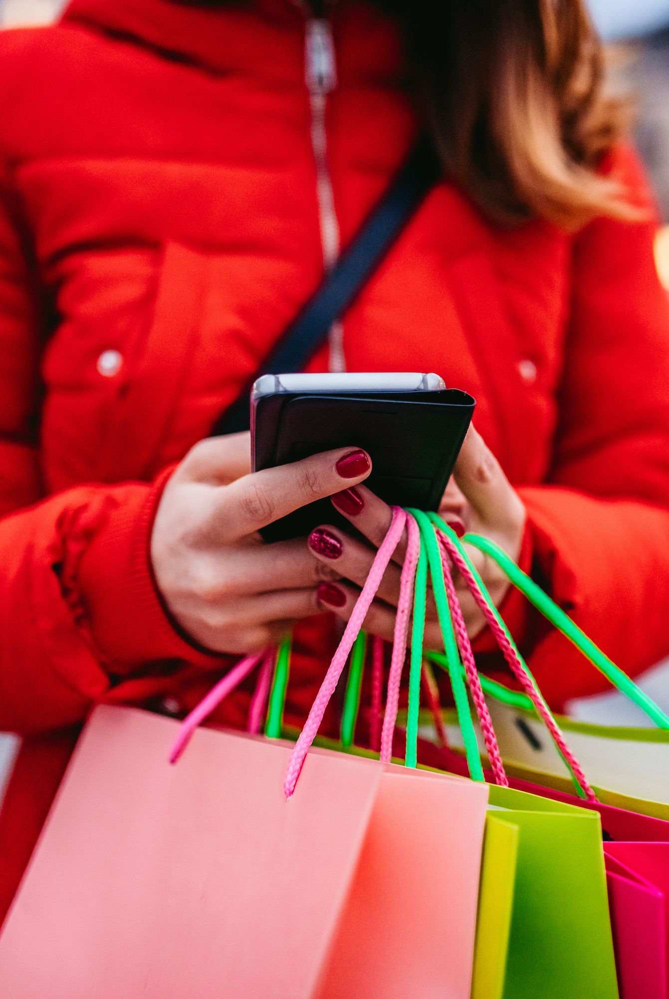 woman with shopping bags using phone